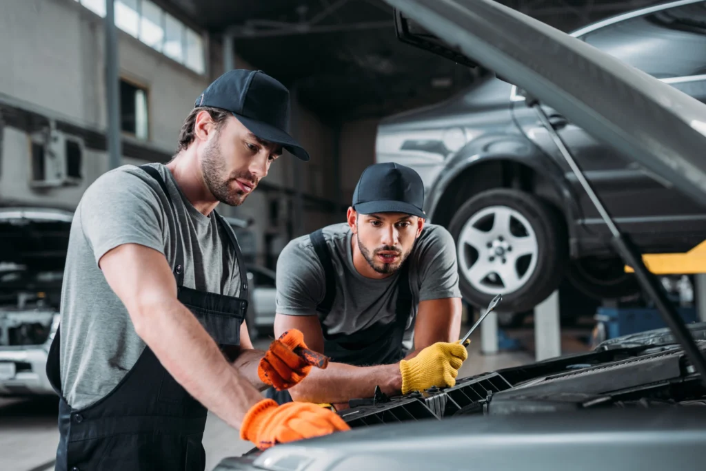 Profesionales manuales reparando auto