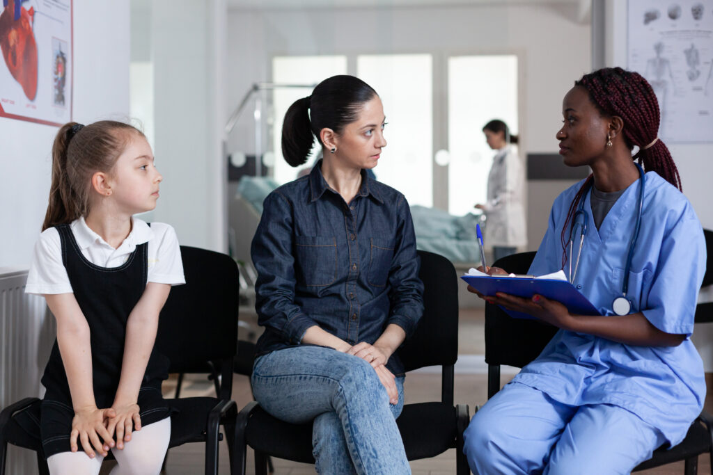 Mujer adulta y niña en consulta en hospital pediátrico