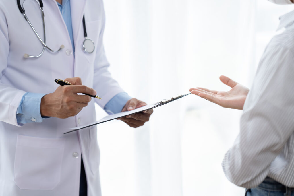 Médico y paciente sentados y hablando durante el examen médico.