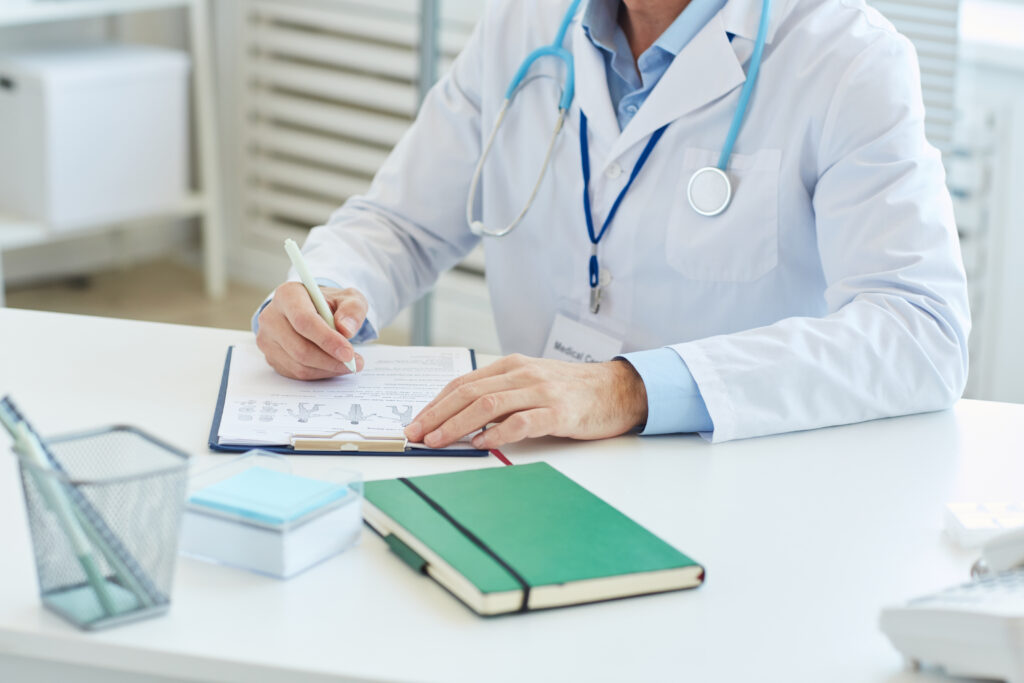Médico llenando el informe de pacientes en la clínica