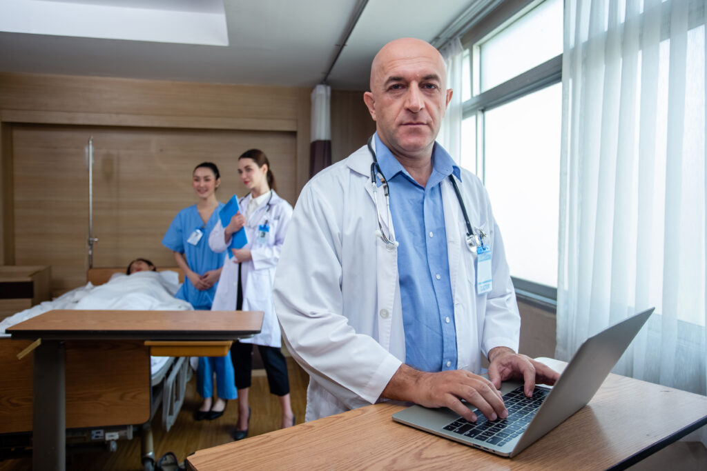 Doctor masculino usando una laptop para revisar la condición del paciente