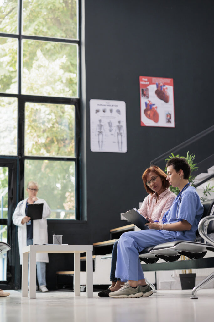 Asistente médico atendiendo a un paciente de edad avanzada en el hospital.